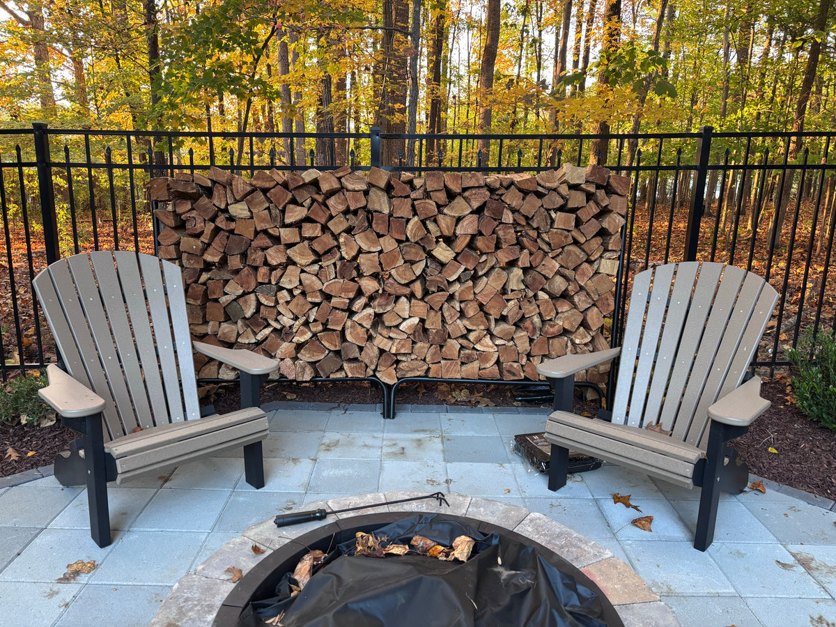 Two chairs pulled up to a fire pit, with a full rack behind